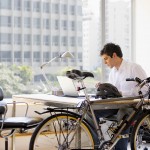 Bicycle by desk and businessman using laptop